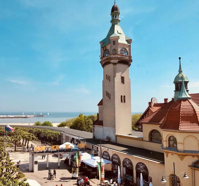 Sopot lighthouse and historic buildings beside the beach.